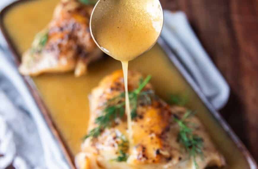 A spoon dripping some butter garlic sauce over fish