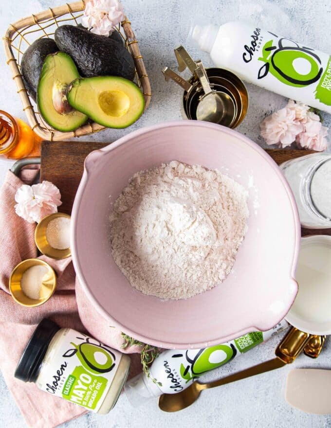 Ingredients to make the mayonnaise biscuits on a bowd including flour, baking powder, sugar, salt, milk and mayonnaise 