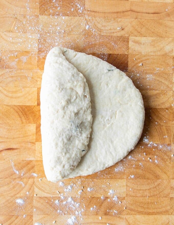 The dough on a wooden board folded in thirds 