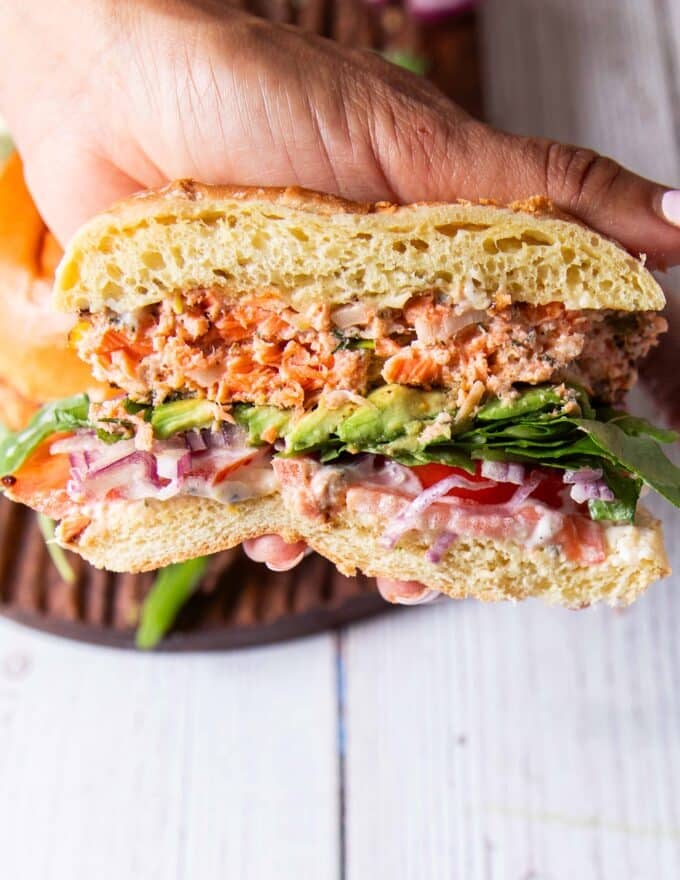 Juicy homemade salmon burger with lettuce and aioli cut in half