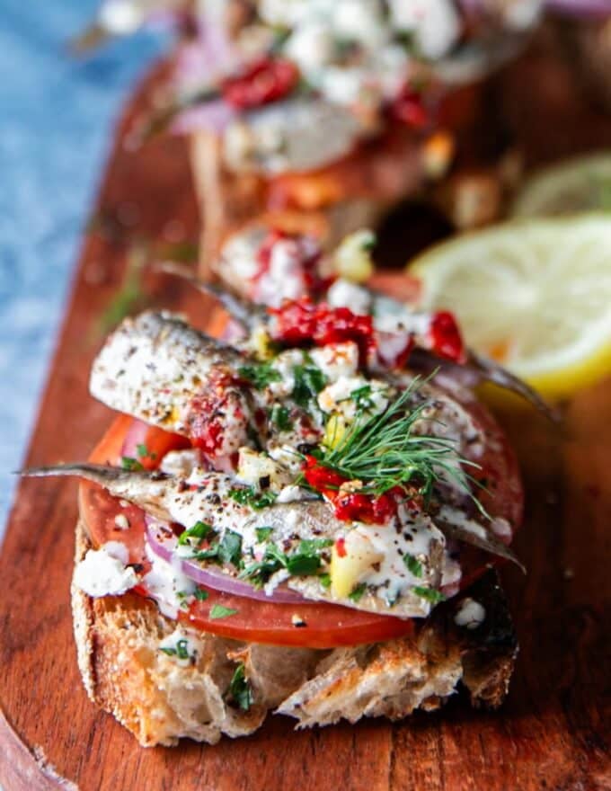 very close shot of a side view showing the layers of toppings on a sardines toast