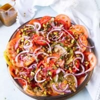 All the toppings added over the tomato carpaccio plate