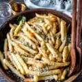 homemade truffle fries close up in a wooden bowl dressed with truffle oil, parmesan cheese, parsley and garlic