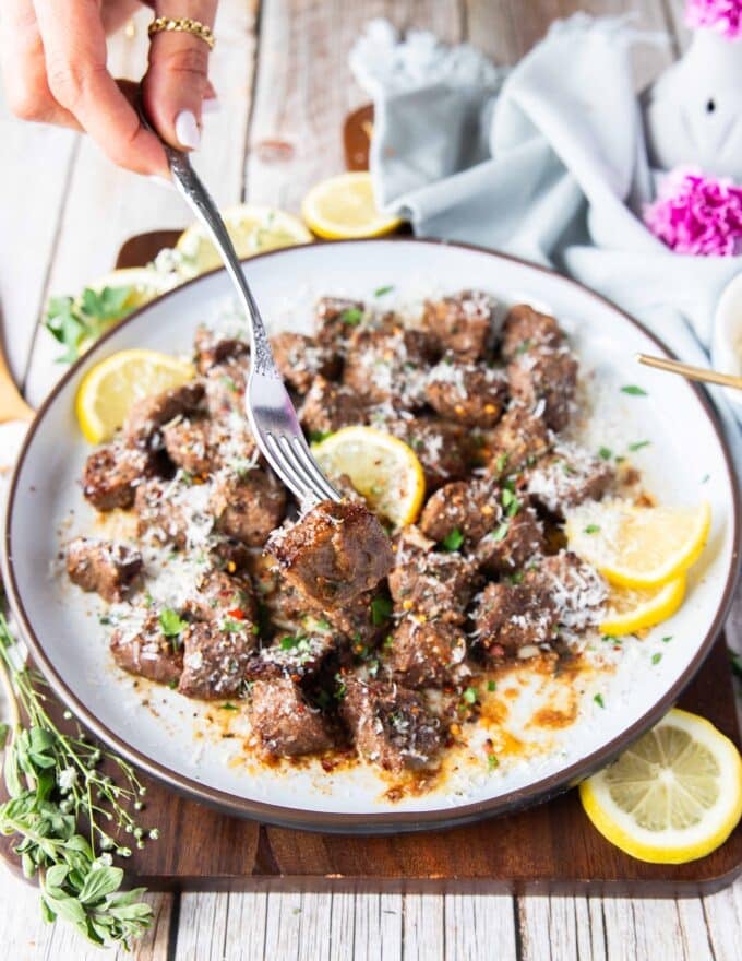 A fork holding on steak bite close up showing what are steak bites