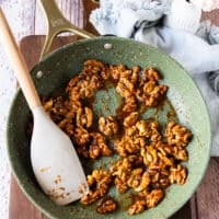 Golden walnuts with a glossy shine in the skillet now ready to cool
