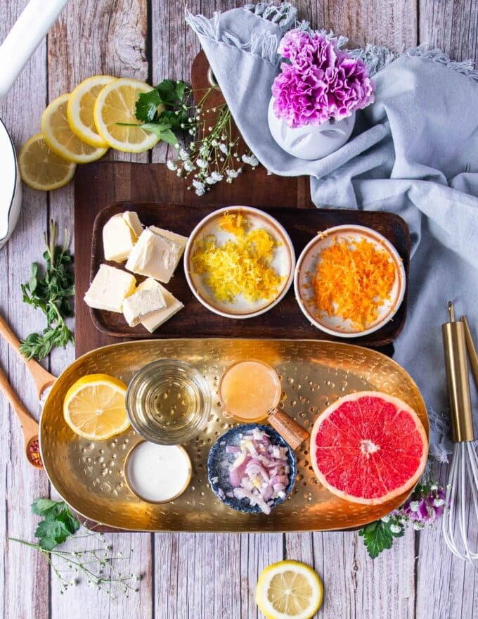 ingredients needed to make citrus beurre blanc including a variety of citrus juices and zests, some cold unsalted butter, shallots, white wine