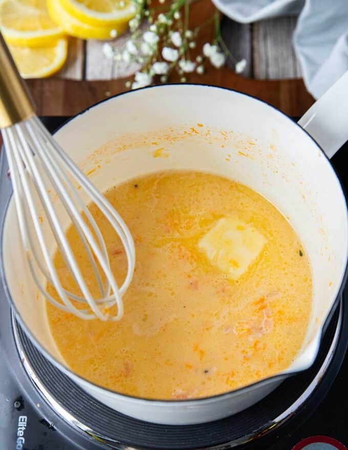 Whisking the butter into the beurre blanc one a time to make beurre blanc sauce 