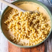 cooked pasta is added to the cheese sauce