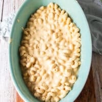 half the pasta in an oven safe dish spread