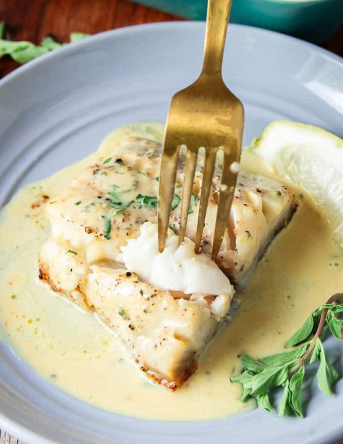 succulent flaky chilean sea bass with a fork showing how juicy it is 