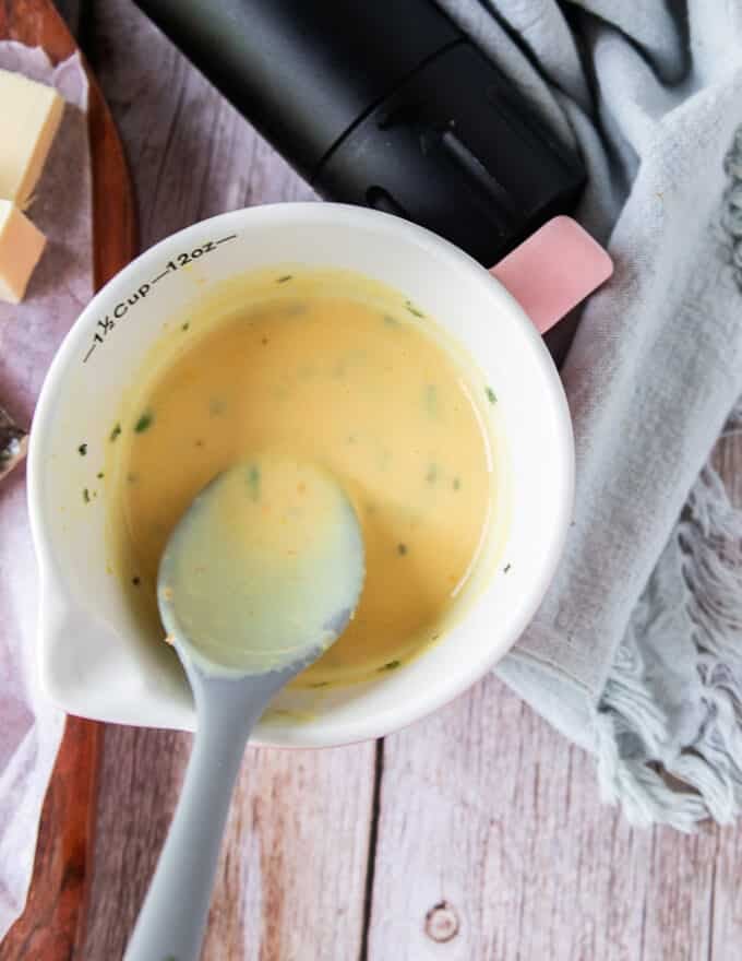 A bowl of citrus beurre blanc and spoon 