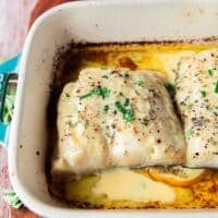 baked chilean sea bass in a dish with citrus beurre blanc on top