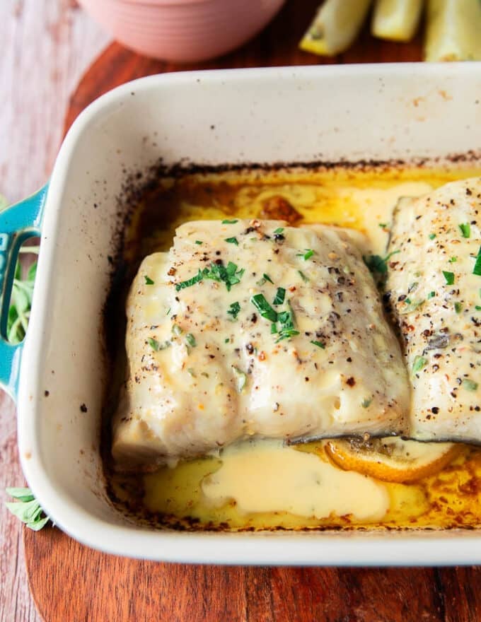 baked chilean sea bass in a dish with citrus beurre blanc on top