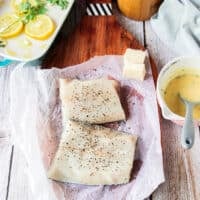 chilean sea bas fillets seasoned with salt and pepper on a board