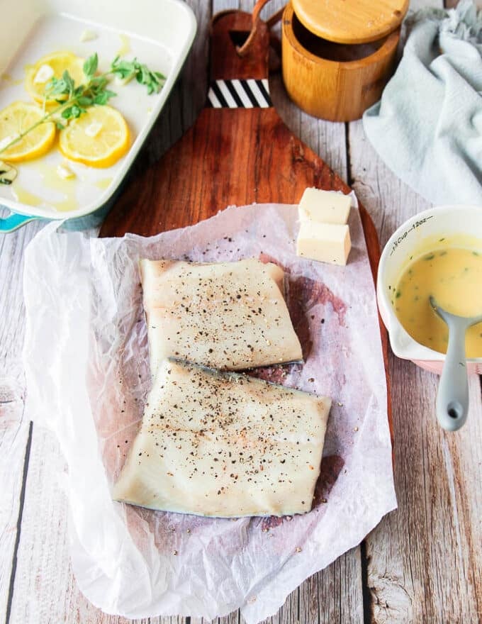 chilean sea bas fillets seasoned with salt and pepper on a board 