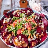 close up of thinly sliced beet carpaccio with arugula, walnuts and blue cheese