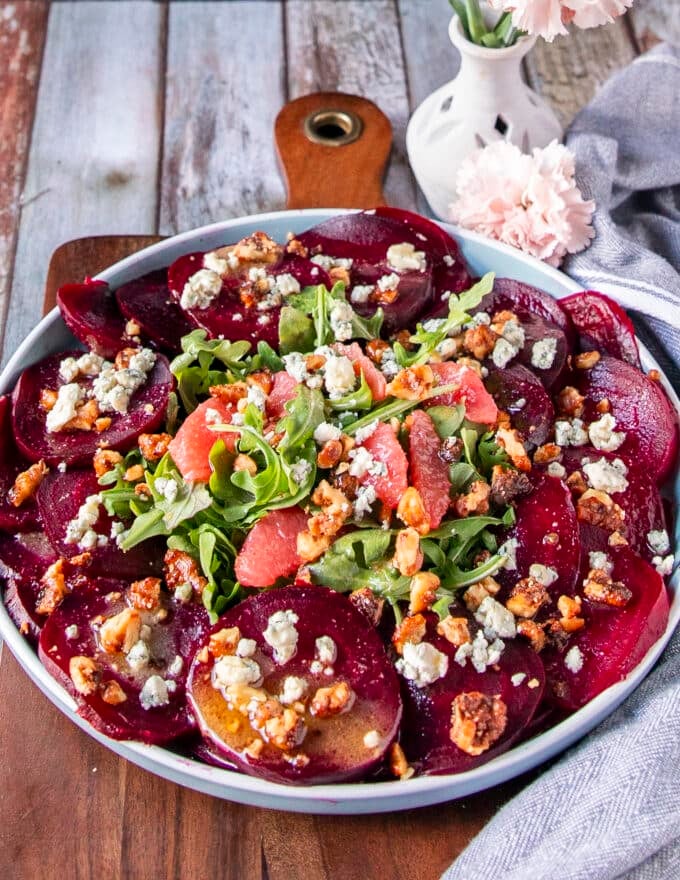 close up of thinly sliced beet carpaccio with arugula, walnuts and blue cheese