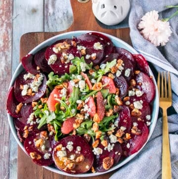 Beet Carpaccio on a plate with blue cheese crumbles and walnuts