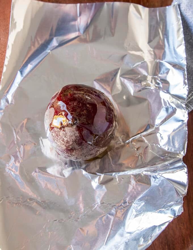 one beetroot is placed in a foil drizzled with olive oil and salt to roast