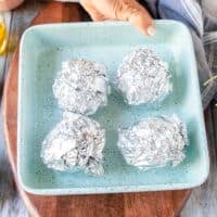 4 wrapped beets individually in foil on a baking sheet ready to roast