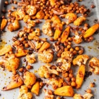 tender and sweet caramelized roast cauliflower and crunchy chickpeas roasted in a baking sheet ready to make cauliflower salad.