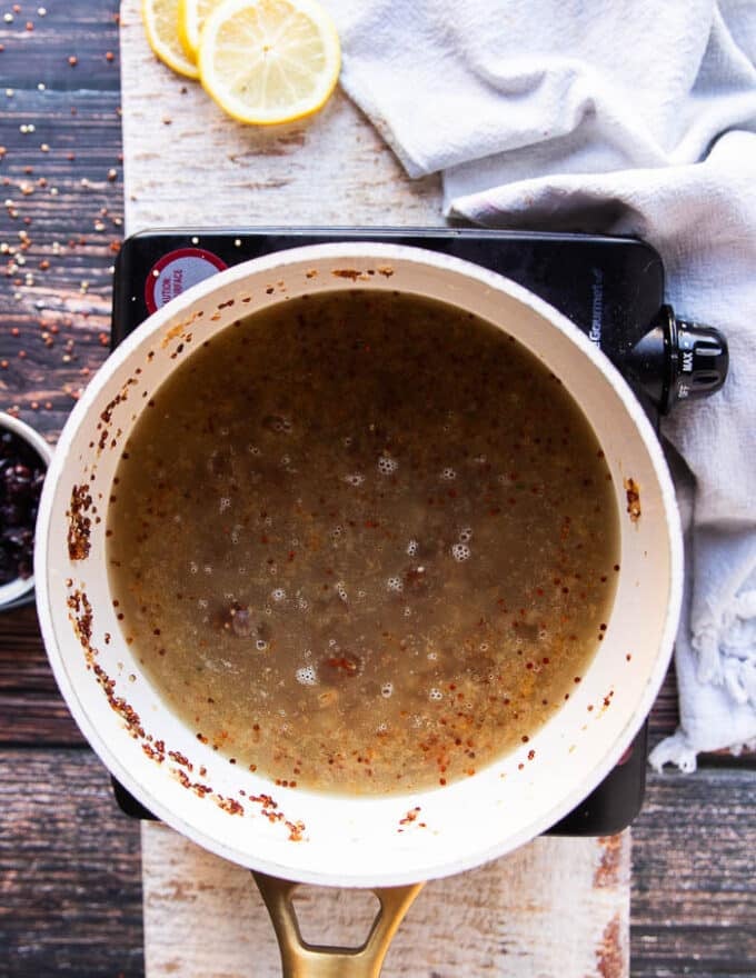Broth is added to cook and steam the quinoa pilaf