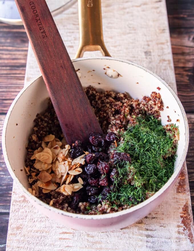 adding cranberries and toasted almonds, and herbs to the pilaf