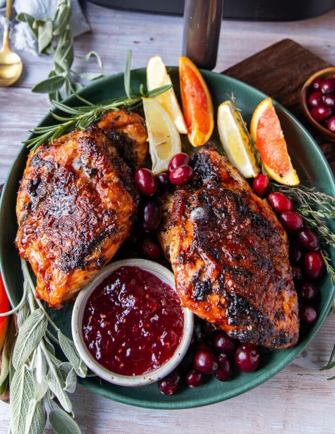 two pieces of air fryer turkey breast on a plate with cranberry sauce 