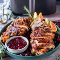 Juicy air fryer turkey breasts, sliced with crispy skin served with cranberry sauce