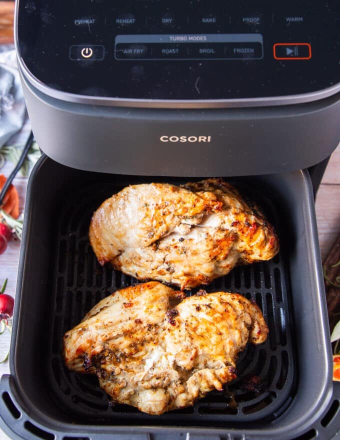 flipped turkey breast in an air fryer basket ready to conitnue cooking 