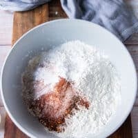 Seasoning is added to the bowl of flour and cornstarch