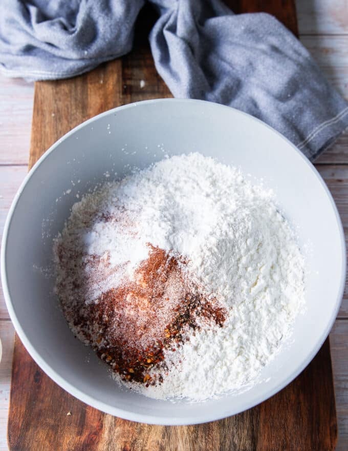 Seasoning is added to the bowl of flour and cornstarch