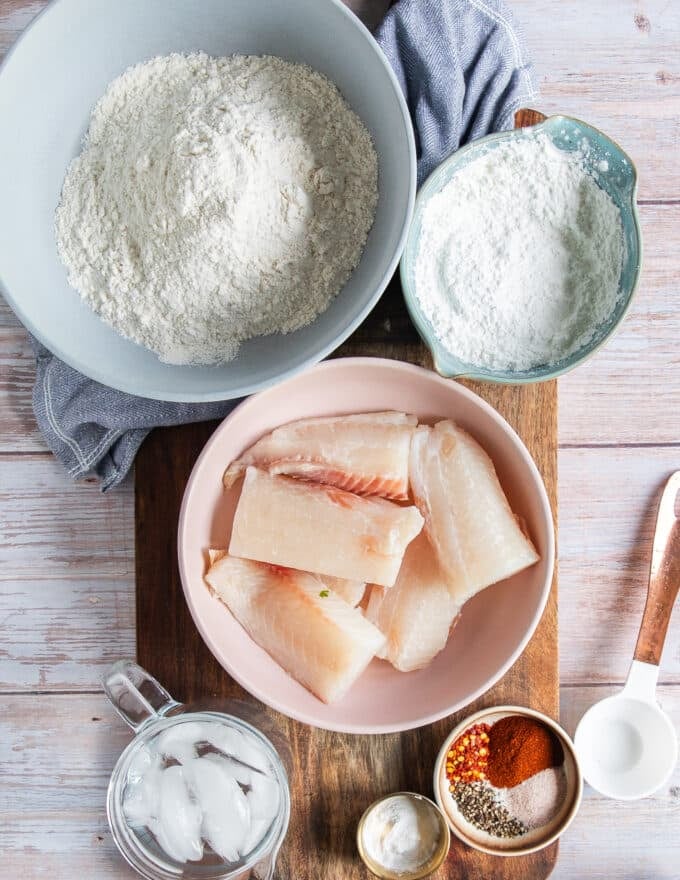 all ingredients needed on a board to make fish and chips recipe