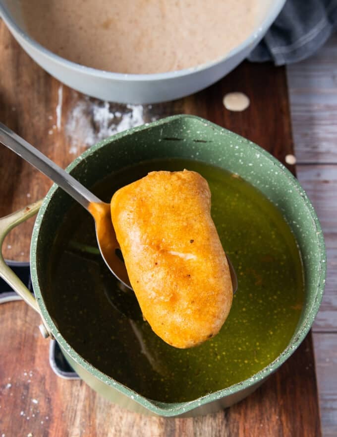 Perfectly golden and crisp fried fish in a slotted spoon lifted from the oil
