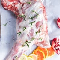 Fresh rosemary and garlic cloves inserted in the incisions along the lamb shoulder.