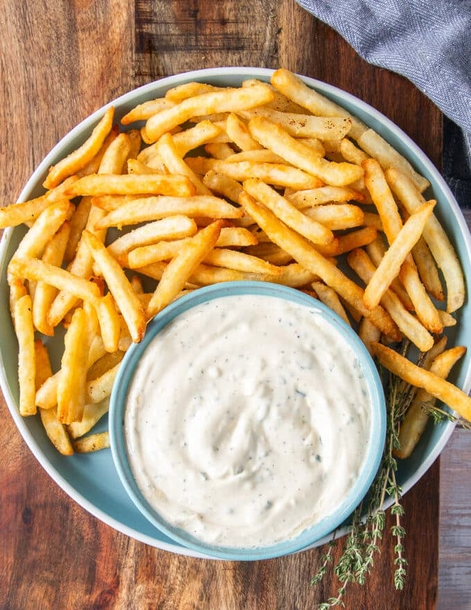 Truffle aioli in a jar with some french fries 
