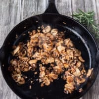 golden brown mushrooms cooking in the same skillet of the steak