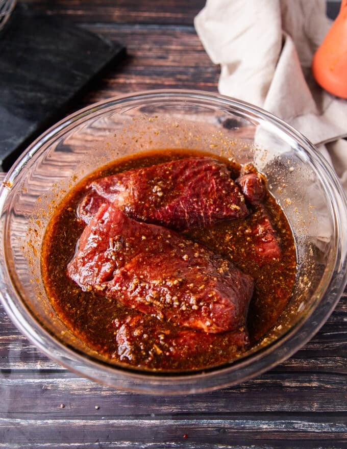 The flank steak is added to marinade bowl and ready to marinade.