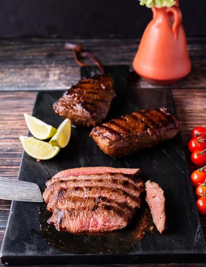 Flank steak is being sliced against the grain for a super tender cut
