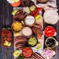 The taco board is assembled with the sliced flank steak, all the taco toppings, tortillas and more!