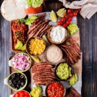 Flank Steak tacos all laid out in a taco board to allow each person to assemble their own