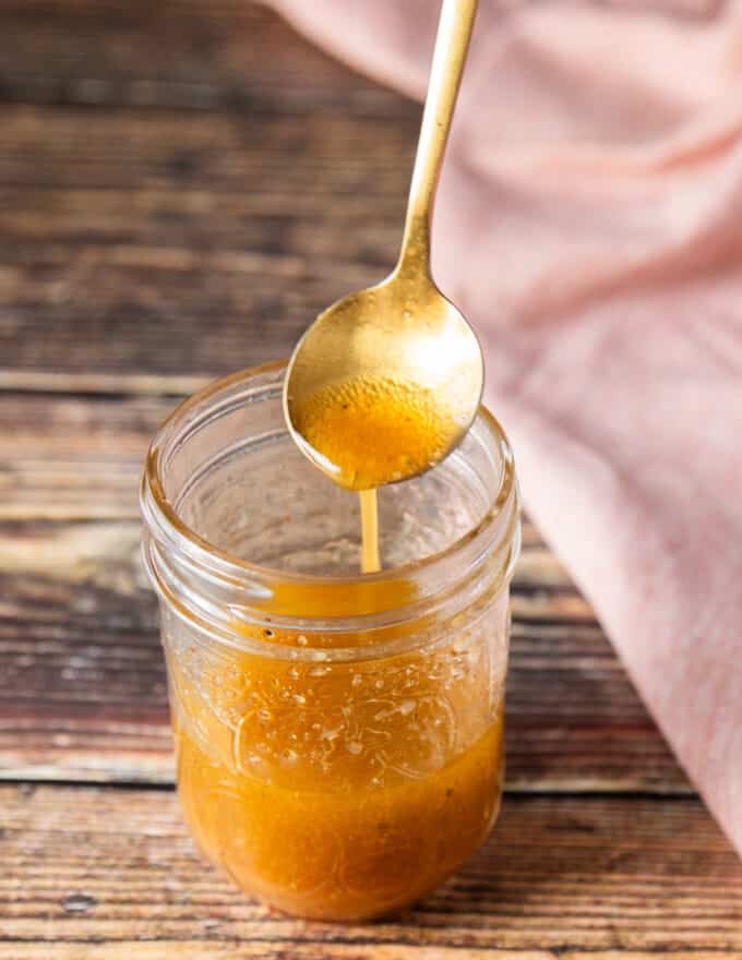 A spoon drizzling a maple vinaigrette showing consistency