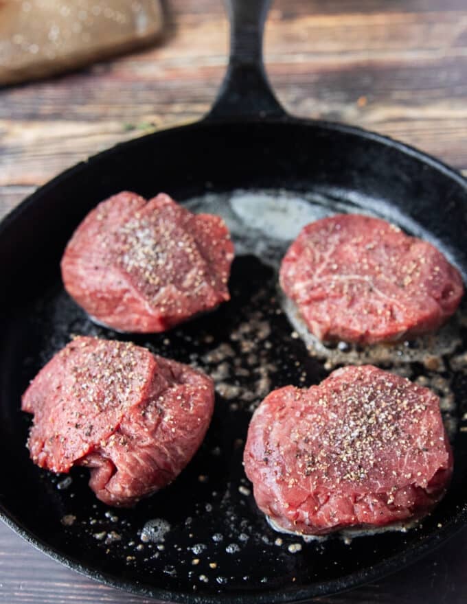 steak searing in a cast iron pan to make the sauce 