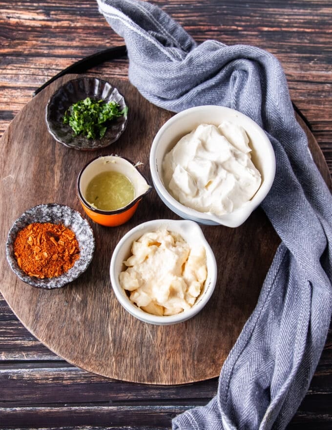 ingredients to make taco sauce on a board in small bowls 