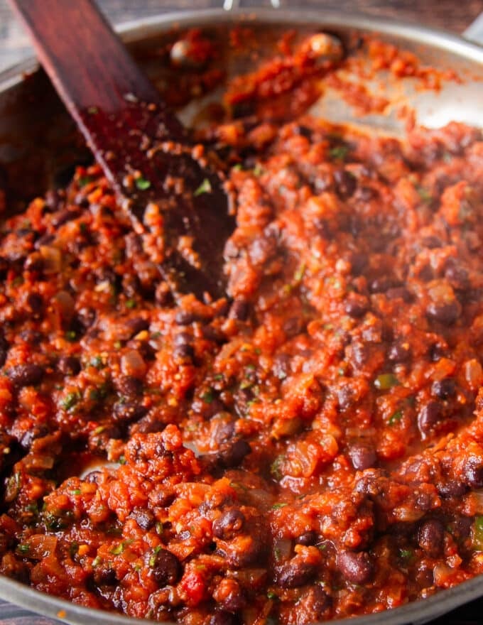 finished mexican black beans recipe is a pan and a close up showng the texture 