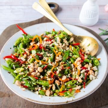perfect snap pea salad all dressed up with crunchy nuts on top