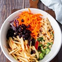 remaining veggies like carrots, apples and onions along with toasted nuts, cranberries and broccoli are all added to a bowl