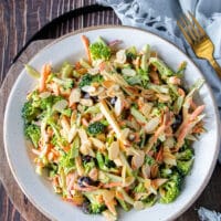 A perfect bowl of broccoli slaw with toasted nuts on top and perfectly dressed