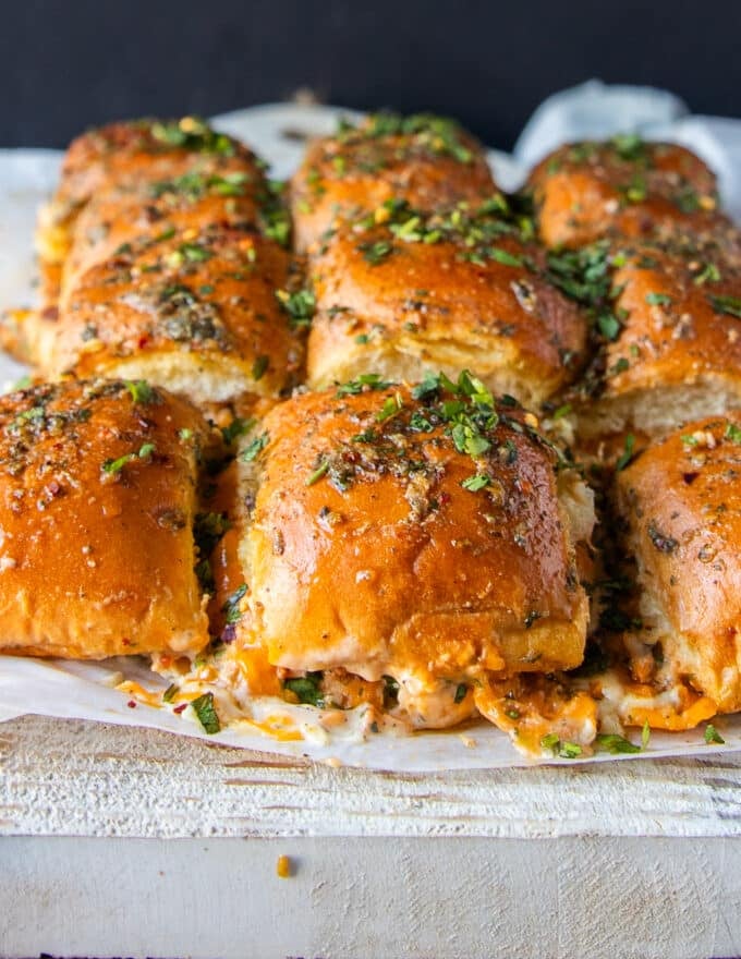 close up of chicken sliders showing melted cheese, chicken, and herb bread