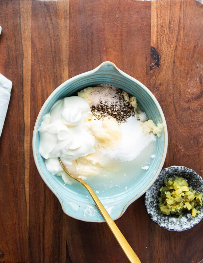 All ingredients of the coleslaw dressing added to a bowl and a whisk is used to blend it later